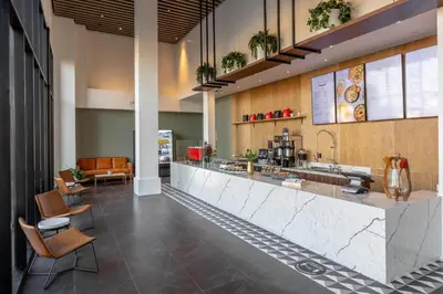 a kitchen with a counter and chairs in a building at The Glenmark, Glendale, a Tribute Portfolio Hotel in Glendale