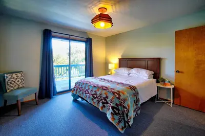 a bedroom with a bed and a large window at The Atomic Squirrel Lodge Lake Gregory Getaway! in Crestline