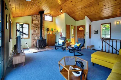 a living room with a couch and a fireplace at The Atomic Squirrel Lodge Lake Gregory Getaway! in Crestline