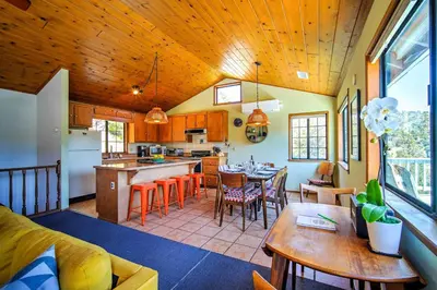 a kitchen and living room with a table and chairs at The Atomic Squirrel Lodge Lake Gregory Getaway! in Crestline