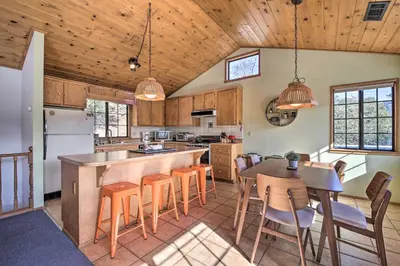 a kitchen with wooden ceilings and a table and chairs at The Atomic Squirrel Lodge Lake Gregory Getaway! in Crestline