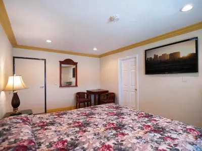 a bedroom with a bed with a floral bedspread at Parkside Inn in Long Beach