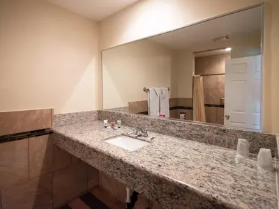 a bathroom with a sink and a large mirror at Parkside Inn in Long Beach