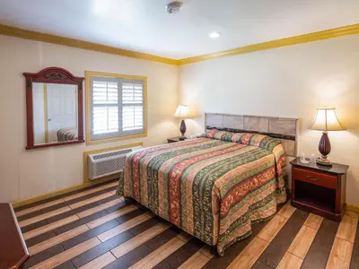 a bedroom with a bed and a window and a mirror at Parkside Inn in Long Beach
