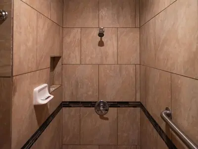a bathroom with a shower with a urinal at Parkside Inn in Long Beach