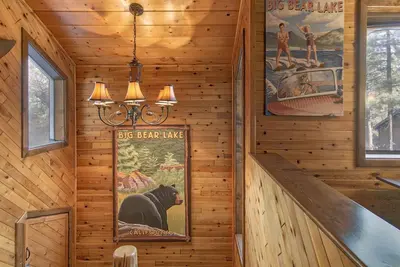 a staircase in a wooden cabin with a sign on the wall at Luxury Lodge-1888 by Big Bear Vacations in Big Bear Lake