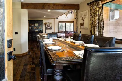 a dining room with a long table and leather chairs at Luxury Lodge-1888 by Big Bear Vacations in Big Bear Lake