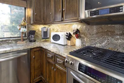 a kitchen with a stove and a microwave at Luxury Lodge-1888 by Big Bear Vacations in Big Bear Lake