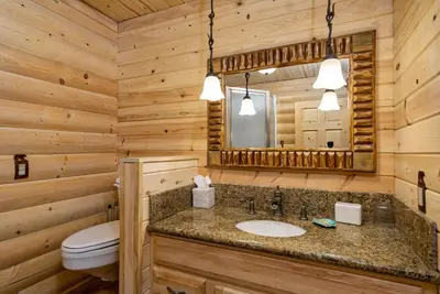 a bathroom with a sink and a toilet and a mirror at Woodland Log-1887 by Big Bear Vacations in Big Bear Lake