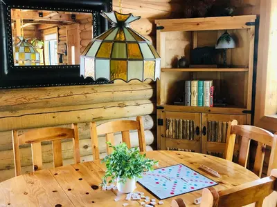 a dining room with a wooden table and a chandelier at Woodland Log-1887 by Big Bear Vacations in Big Bear Lake