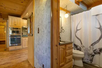 a bathroom with a toilet and a shower curtain at Woodland Log-1887 by Big Bear Vacations in Big Bear Lake