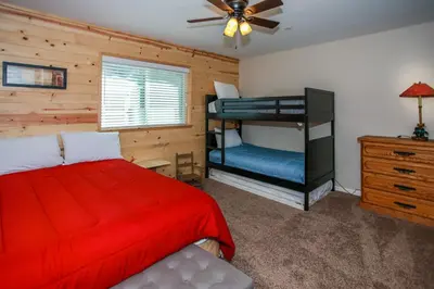 a bedroom with a red bed and a ceiling fan at Kitkats Hideaway-1874 by Big Bear Vacations in Big Bear Lake