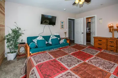 a living room with a blue couch and a tv at Kitkats Hideaway-1874 by Big Bear Vacations in Big Bear Lake