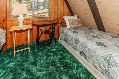 a bedroom with a bed and a table and a window at Makin' Memories At Summit-1683 by Big Bear Vacations in Big Bear Lake