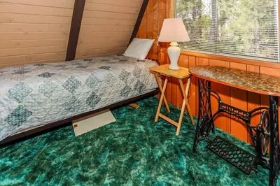 a bedroom with a bed and a table with a lamp at Makin' Memories At Summit-1683 by Big Bear Vacations in Big Bear Lake
