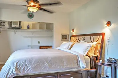 a bedroom with a bed with white sheets and a ceiling fan at 3 Mi to Dtwn Dining! Long Beach Condo with Balcony in Long Beach