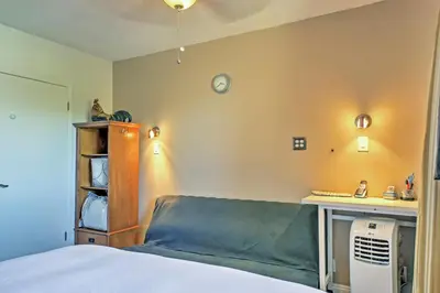 a bedroom with a bed and a desk with a clock on the wall at 3 Mi to Dtwn Dining! Long Beach Condo with Balcony in Long Beach