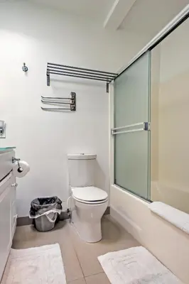 a bathroom with a toilet and a glass shower at 3 Mi to Dtwn Dining! Long Beach Condo with Balcony in Long Beach