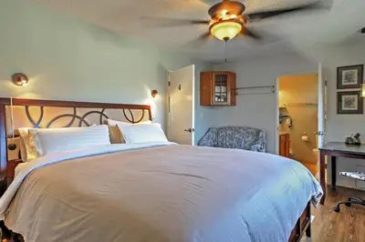 a bedroom with a large bed with a ceiling fan at 3 Mi to Dtwn Dining! Long Beach Condo with Balcony in Long Beach