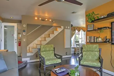 a living room with two chairs and a staircase at Unique Long Beach House with Patio, Grill and Balcony in Long Beach