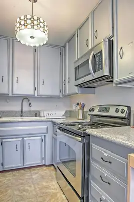 a kitchen with white cabinets and stainless steel appliances at Downtown Long Beach Condo - 1 Mi to Boardwalk! in Long Beach