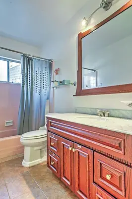 a bathroom with a sink and a toilet and a mirror at Downtown Long Beach Condo - 1 Mi to Boardwalk! in Long Beach