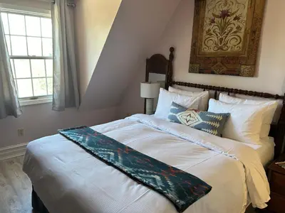 a bedroom with a large bed with a painting on the wall at Arrowhead Lake Inn in Lake Arrowhead