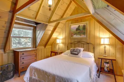 a bedroom with a white bed in a attic at Vintage Snow White Cottage about 2 Miles to Village! in Lake Arrowhead