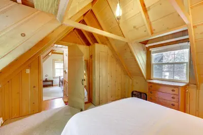 a bedroom with a white bed and a wooden ceiling at Vintage Snow White Cottage about 2 Miles to Village! in Lake Arrowhead