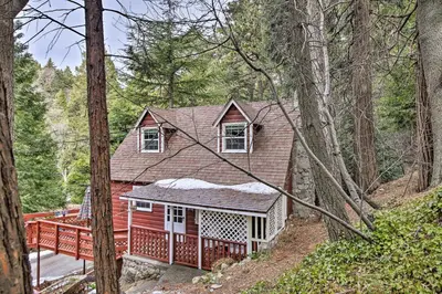 a red house with a deck in the woods at Vintage Snow White Cottage about 2 Miles to Village! in Lake Arrowhead