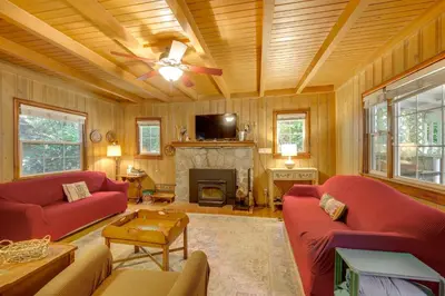 a living room with two red couches and a fireplace at Vintage Snow White Cottage about 2 Miles to Village! in Lake Arrowhead