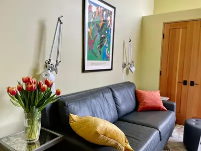 a living room with a couch and a vase of flowers at Del Rey/Culver City Dream Oasis in Los Angeles