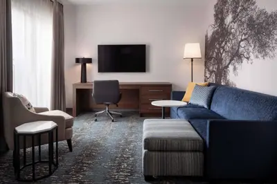 a living room with a blue couch and a tv at Residence Inn Los Angeles Glendale in Glendale