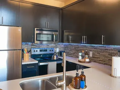 a kitchen with black cabinets and a stainless steel refrigerator at Sunny 1BDR centrally located in Marina del Rey in Los Angeles