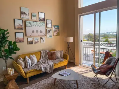 a living room with a yellow couch and a balcony at Sunny 1BDR centrally located in Marina del Rey in Los Angeles