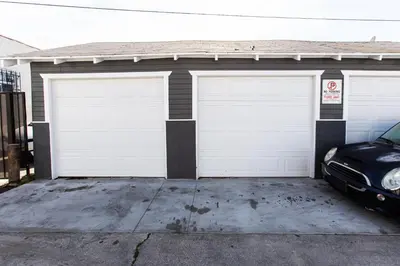 a garage with two white garage doors and a car at Long Beach Duplex King Bed Pet Friendly Nurses Surgeon Business Travelers Near St Marys Medical Center & Downtown in Long Beach