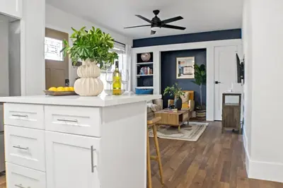 a kitchen with white cabinets and a ceiling fan at Newly Renovated Gem Mins to Convention Center, Beaches and Downtown LB A in Long Beach
