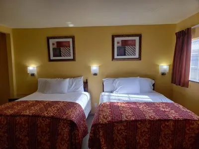 a hotel room with two beds and two pictures on the wall at Providencia Motel in Burbank