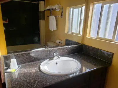 a bathroom with a white sink and a window at Providencia Motel in Burbank