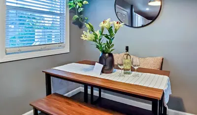 a table with a bottle of wine and flowers on it at Traveler's Pick Cozy, Near Beach & Dtwn,Prkg LB C in Long Beach