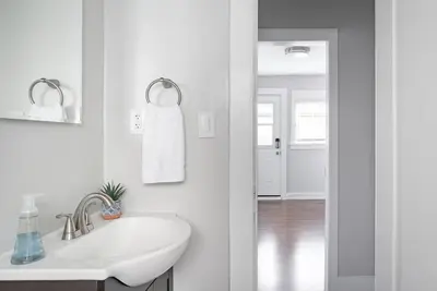 a white bathroom with a sink and a mirror at Historic Hm Mins to Beach, Convention Ctr Parking LB E in Long Beach