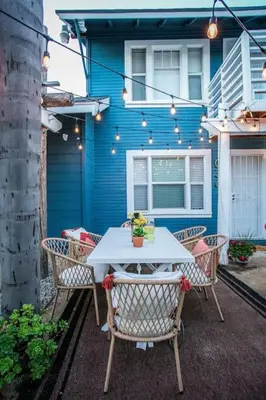 a white table and chairs in front of a blue building at Historic Hm Mins to Beach, Convention Ctr Parking LB E in Long Beach