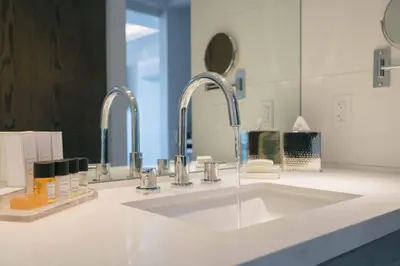 a bathroom with a sink and two faucets at H2O Hermosa Beach Hotel in Hermosa Beach