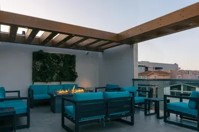 a patio with blue chairs and a table and a painting at H2O Hermosa Beach Hotel in Hermosa Beach
