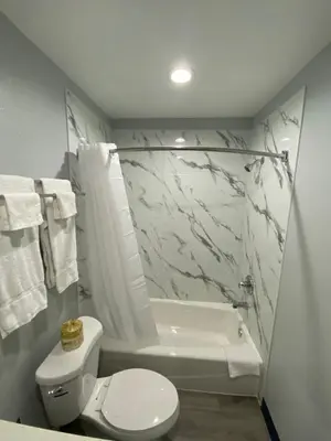 a bathroom with a toilet and a tub and a sink at Motel 66 Los Angeles in Los Angeles