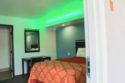 a bedroom with a bed and a green ceiling at Arlington Motel in Long Beach