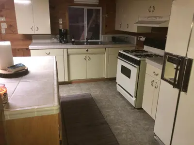 a kitchen with white cabinets and a stove top oven at sequoia National Forest CabinH in Panorama Heights