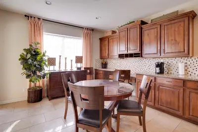 a kitchen with wooden cabinets and a table and chairs at Single-Story San Bernardino Home with Valley Views! in San Bernardino