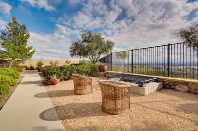a patio with a grill and chairs and a fence at Single-Story San Bernardino Home with Valley Views! in San Bernardino