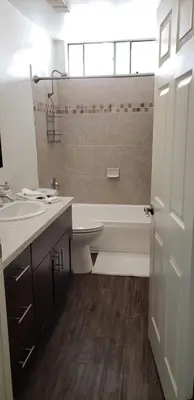 a bathroom with a tub and a toilet and a sink at Skyline Views 1-Bedroom with Balcony and Pool in Los Angeles
